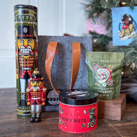 Mistletote Gift Basket includes Ginger Snap Cookie Tin, Bob's Nuts Tin, Caramel Candy Bag, and our Nutcracker Glass Ornament