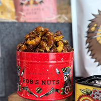 Red tin labeled 'Bob's Nuts' filled with roasted nuts, with a blurred background.