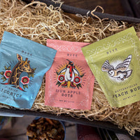 Three colorful candy packages on a bed of excelsior