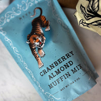 Cranberry Almond Muffin Mix package with a tiger illustration on a blue background