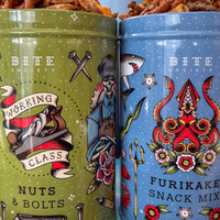 Two colorful snack tins with tattoo-style designs and 'Bite Society' branding.
