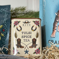 Tulsi Spice Tea packaging with cowboy boot and horseshoe design on a beige background.