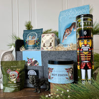 Snow Day Holiday Gift Basket. Collection of holiday-themed products including candles, tea and cocoa tins, and ginger snap cookie tin.