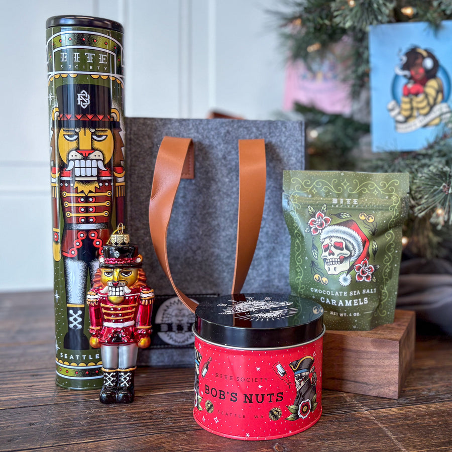 Mistletote Gift Basket includes Ginger Snap Cookie Tin, Bob's Nuts Tin, Caramel Candy Bag, and our Nutcracker Glass Ornament