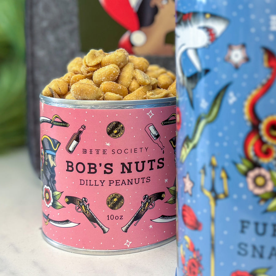 Can of 'Bob's Nuts Dilly Peanuts' with colorful label with Furikake Snack Mix in foreground
