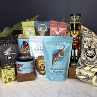 Christmas Morning Gift Basket. Assorted food items including coffee, tea, and snacks on a marble surface with a dark background.