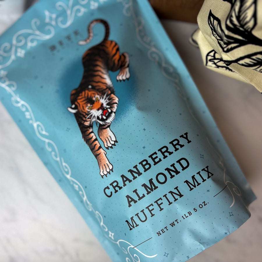 Cranberry Almond Muffin Mix package with a tiger illustration on a blue background