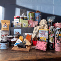 8 Crazy Nights Hanukkah Holiday Gift Basket filled with tins of cookies, snacks, tea, and cocoa alongside a packed charcuterie cooler, pickles and candy.