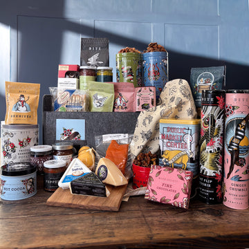 8 Crazy Nights Hanukkah Holiday Gift Basket filled with tins of cookies, snacks, tea, and cocoa alongside a packed charcuterie cooler, pickles and candy.