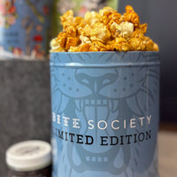 Blue container with popcorn labeled 'Life Society Limited Edition' on a blurred background