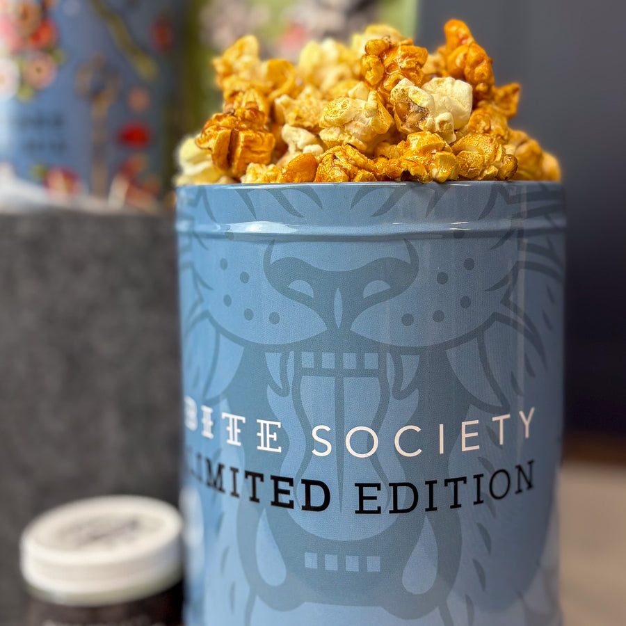 Blue container with popcorn labeled 'Life Society Limited Edition' on a blurred background