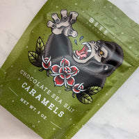 Green packaging of chocolate sea salt caramels with a graphic design on a white background